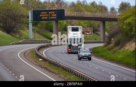 East Lothian, Schottland, Großbritannien, 17. April 2020. Covid-19 Absperrung auf A1: Da das Land in die zweite Phase der angekündigten Verlängerung der Sperrmaßnahmen eintritt, ist die normalerweise befahrene A1-Schnellstraße, die Schottland mit England verbindet, fast menschenleer, mit sehr wenig Verkehr, abgesehen von den wichtigen Reisen und einem Eddie Stobart-Lastwagen. Eine über dem Kopf liegende Gantry hat die Pandemiemeldung Stay Safe, Protect NHS, Save Lives Stockfoto