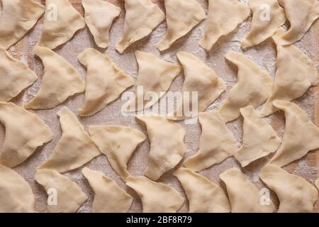 Auf einem Schneidebrett liegen Teigknödel mit Kartoffeln. Kochen zu Hause. Stockfoto