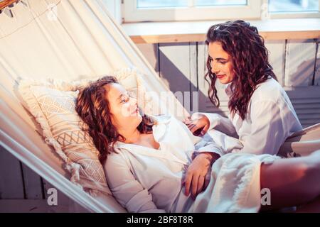 Junge hübsche Schwestern zu Hause am frühen Morgen in der Hängematte, Lifestyle casual Personen Konzept Stockfoto