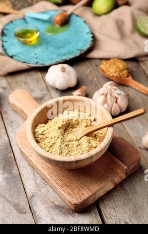 Schale mit trockenem Senf auf Holzhintergrund Stockfoto