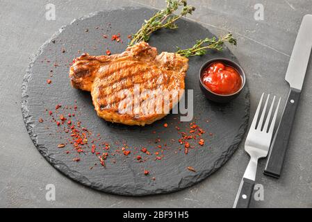 Gekochtes Schweinefleisch Steak und Sauce auf Schieferplatte Stockfoto