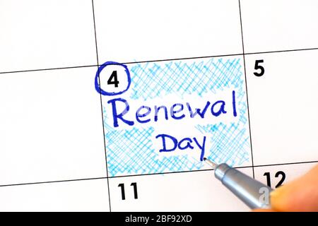 Frau Finger mit Stift Schreiben Erinnerung Erneuerung Tag im Kalender. Mai 04. Stockfoto