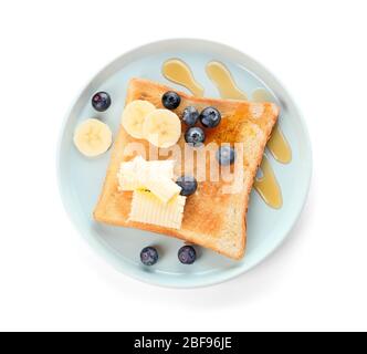 Schmackhaftes geröstetes Brot mit Honig, Butter und Früchten auf weißem Hintergrund Stockfoto