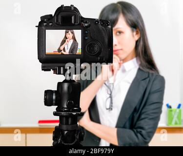 Asiatisch-amerikanischer Lehrer Streaming-Klasse mit Kamera für Schüler zu Hause Stockfoto