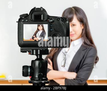 Asiatisch-amerikanischer Lehrer Streaming-Klasse mit Kamera für Schüler zu Hause Stockfoto