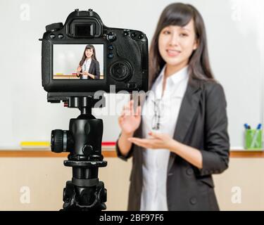 Asiatisch-amerikanischer Lehrer Streaming-Klasse mit Kamera für Schüler zu Hause Stockfoto