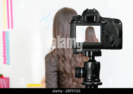 Asiatisch-amerikanischer Lehrer Streaming-Klasse mit Kamera für Studenten zu Hause schreiben meinen Namen ist auf Whiteboard Stockfoto