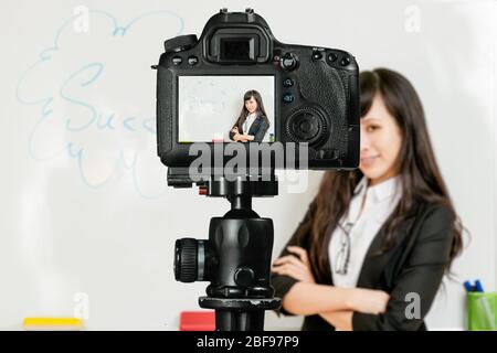 Asiatisch-amerikanischer Lehrer Streaming-Klasse mit Kamera für Schüler zu Hause Stockfoto