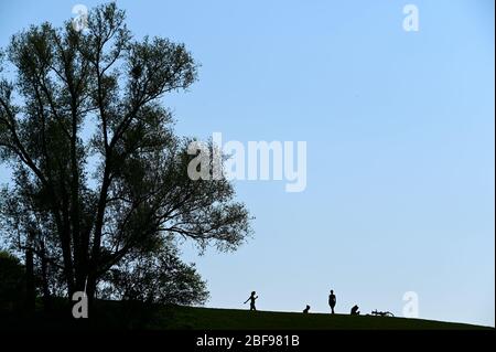 Kassel, Deutschland. April 2020. Vier junge Menschen sind in der Fulda-Aue als Silhouetten zu erkennen. Das Wetter verspricht über das Wochenende Frühsommer zu werden. Quelle: Uwe Zucchi/dpa/Alamy Live News Stockfoto