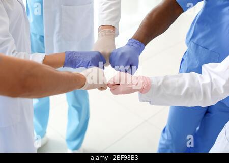 Gruppe von Ärzten, die sich in der Klinik zusammenfügen. Einheitlichkeit Stockfoto