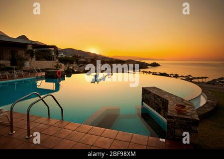 Sonnenaufgang am Pool des Kakkos Beach Hotels (nur für Erwachsene), Koutsounari, Gemeinde Ierapetra, Lassithi, Kreta, Griechenland. Stockfoto