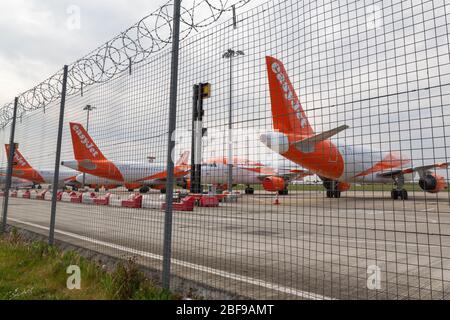 Southend-on-Sea, Großbritannien. April 2020. Mehrere EasyJet-Flugzeuge in orange und weißer Lackierung parken hinter einem Stacheldrahtzaun am Flughafen London Southend. Die Flugzeuge sind stationär, umgeben von roten und weißen Barrieren, was auf eine Sperrzone oder einen Wartungsbereich hinweist. Nach Maßnahmen, die von europäischen Staaten und großen europäischen Fluggesellschaften als Reaktion auf die COVID-19-Pandemie ergriffen wurden, sitzen die easyJet-Flugzeuge auf der Start- und Landebahn des Flughafens Southend. Penelope Barritt/Alamy Live News Stockfoto