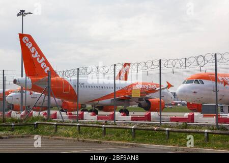 Southend-on-Sea, Großbritannien. April 2020. EasyJet-Flugzeuge parkten hinter einem Sicherheitszaun am Flughafen London Southend, Essex. Die Flugzeuge tragen die orange-weiße Lackierung der Fluggesellschaft und befinden sich in einem durch Barrieren und Stacheldraht gekennzeichneten Bereich. Nach Maßnahmen, die von europäischen Staaten und großen europäischen Fluggesellschaften als Reaktion auf die COVID-19-Pandemie ergriffen wurden, sitzen die easyJet-Flugzeuge auf der Start- und Landebahn des Flughafens Southend. Penelope Barritt/Alamy Live News Stockfoto