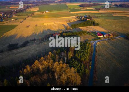 Kleines Dorf zwischen Ackerland und Waldfläche - schöne Frühlingslandschaft in der Nähe von Batorówek, Tafelberge, Polen. Aussicht Stockfoto