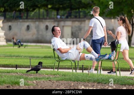 Läufer, die sich auf einem Sitz im Tuileries Garden, Paris, ausruhen Stockfoto