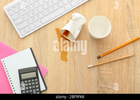 Schreibwaren, PC-Tastatur und verschütteten Kaffee auf dem Bürotisch Stockfoto