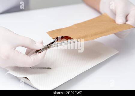 Die Hände nehmen vor dem Maniküre-Verfahren Maniküre-Werkzeuge aus dem Handarbeitsumschlag. Stockfoto