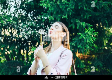 Hübsches Mädchen Modell weht Löwenzahn Lachen in einem Sommer Zeit Stockfoto