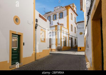 Der Blick auf die gepflasterte Straße von Evora mit der gemütlichen weißen Häusern. Evora. Alentejo. Portugal Stockfoto