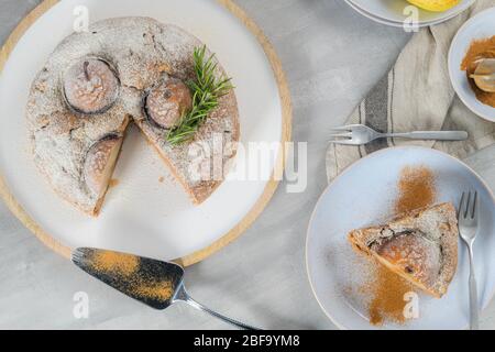 Köstliche Tortenscheibe mit Birne, Ingwer und Zimt auf einem Teller in einer dunklen Küchentheke. Stockfoto