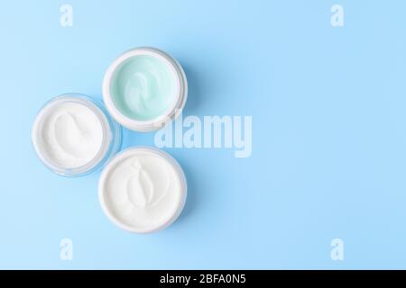 Gläser kosmetische Creme auf farbigen Hintergrund Stockfoto