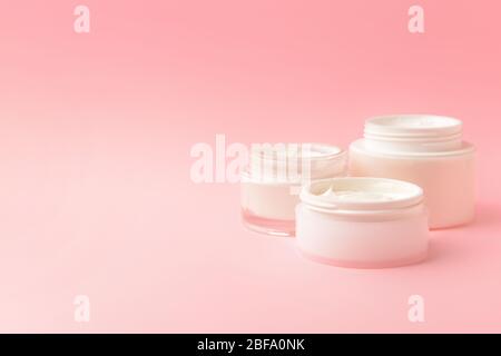 Gläser kosmetische Creme auf farbigen Hintergrund Stockfoto