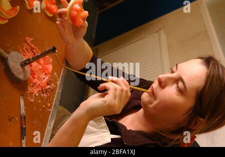Ein Techniker bläst die Flamme eines Bunsun-Brenners in die Prothese, die das Wachs formt Stockfoto