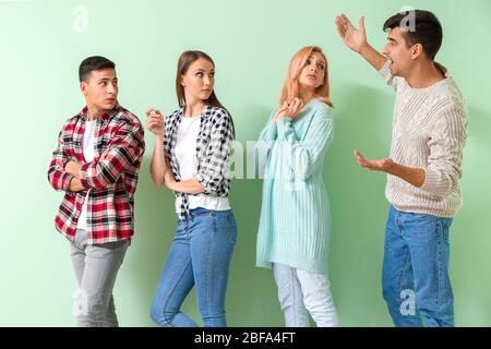 Junge Menschen warten in der Schlange auf farbigen Hintergrund Stockfoto
