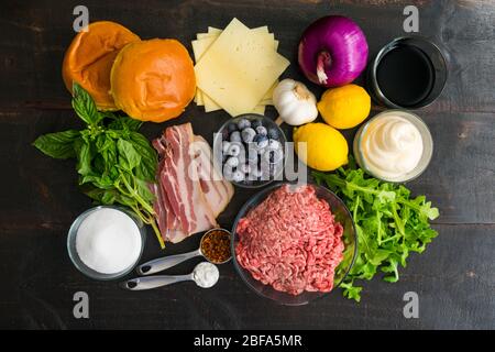 Bacon Burger mit Basilikum Aioli, rot, weiß und Heidelbeere Zutaten: Hackfleisch, Havarti-Käsescheiben und andere Speck-Cheeseburger-Zutaten Stockfoto