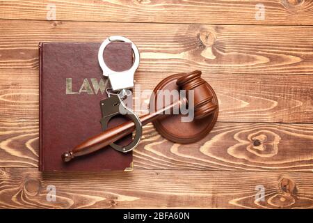 Richtergabel, Buch und Handschellen auf Holzhintergrund Stockfoto