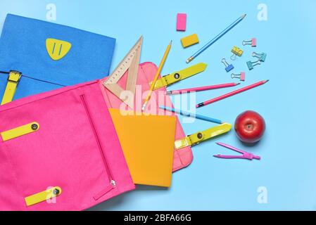 Schule Rucksäcke und Schreibwaren auf farbigen Hintergrund Stockfoto