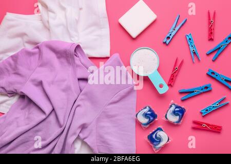 Zusammensetzung mit Kleidung und Waschmittel auf farbigem Hintergrund Stockfoto