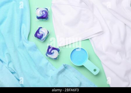 Zusammensetzung mit Kleidung und Waschmittel auf farbigem Hintergrund Stockfoto