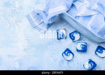 Zusammensetzung mit Kleidung und Waschmittel auf farbigem Hintergrund Stockfoto