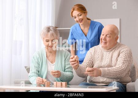 Ältere Menschen mit geistiger Behinderung und Pflegepersonal im Pflegeheim Stockfoto