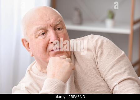 Älterer Mann, der zu Hause an geistiger Behinderung leidet Stockfoto