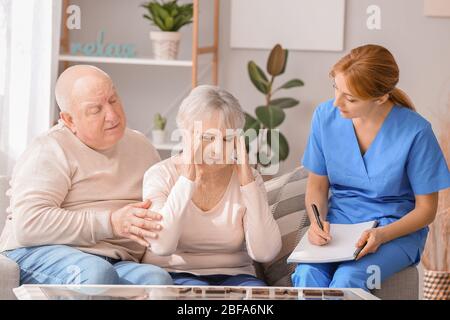 Ältere Menschen mit geistiger Behinderung und Pflegepersonal im Pflegeheim Stockfoto