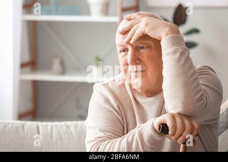 Älterer Mann, der zu Hause an geistiger Behinderung leidet Stockfoto