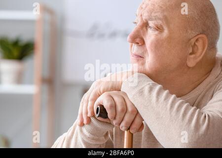 Älterer Mann, der zu Hause an geistiger Behinderung leidet Stockfoto