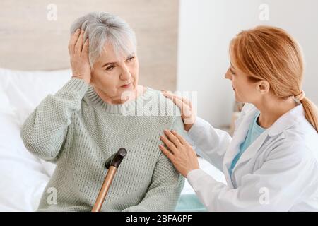 Ältere Frau mit geistiger Behinderung und Arzt zu Hause Stockfoto