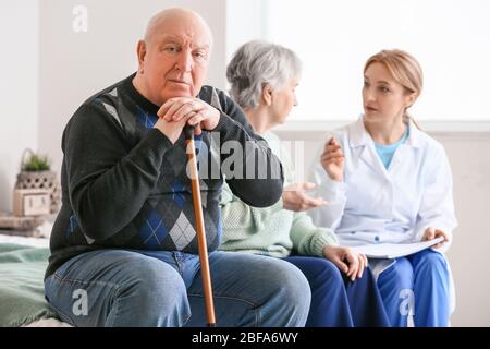 Ältere Menschen mit geistiger Behinderung und Arzt zu Hause Stockfoto