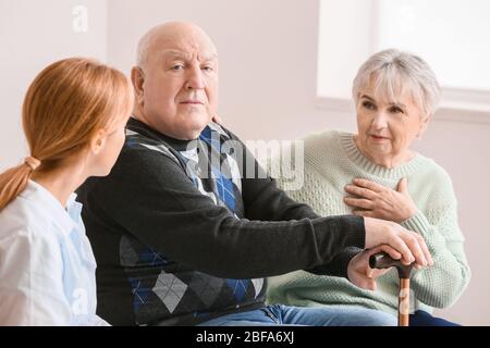 Ältere Menschen mit geistiger Behinderung und Arzt zu Hause Stockfoto