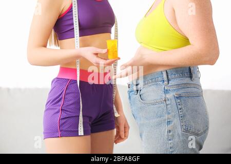 Frauen mit Gewichtsverlust Pillen und Maßband zu Hause Stockfoto