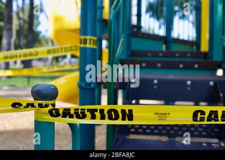 Während COVID-19 und Coronavirus mit Klebeband vom Spielplatz abgestreifelt Stockfoto