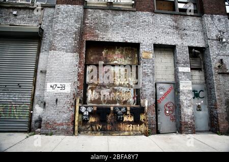 Wand eines Industriegebäudes mit Rollgitter in New York City, NY, USA Stockfoto