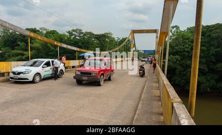 La Hormiga, Putumayo / Kolumbien - 8. März 2020: Menschen und Autos überqueren von der kolumbianischen Seite aus die internationale Brücke über den San Miguel Fluss Stockfoto