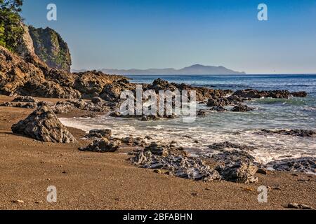 Vulkanische Felsen am Strand von Poley Bay, Coromandel Peninsula, Waikato Region, North Island, Neuseeland Stockfoto