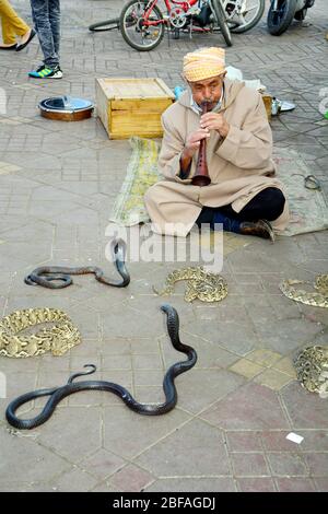 Marrakesch, Marokko - 22. November 2014: Nicht identifizierter Schlangenbeschwörer und Schlangen auf dem Platz Djemaa el-Fna - ein UNESCO-Weltkulturerbe Stockfoto