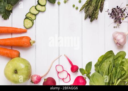 Rahmen mit verschiedenen Gemüse und Kräutern auf dem weißen Holzhintergrund. Stockfoto