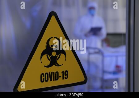 Warnschild für Biohazard an der Tür der ansteckenden Isolationsstation. Konzept der Coronavirus-Epidemie Stockfoto